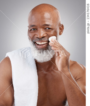 Dermatology, cotton pad and portrait of black man with smile, happiness and anti ageing treatment in studio backdrop. Skin care, cosmetic and happy, mature model with morning skincare or face routine 134176416