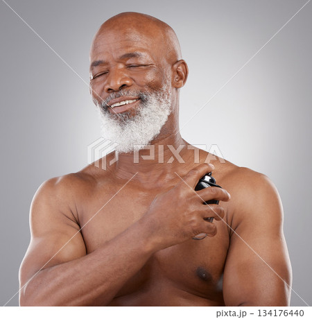 Perfume, smile and senior black man model closed eyes, happy and excited isolated in a gray studio background. Self care, skincare and old male person holding cologne for fragrance in backdrop 134176440