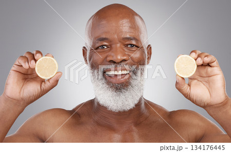 Senior black man, portrait and fruit for vitamin C, skincare or natural nutrition against gray studio background. Happy African American male smile and citrus lemon for healthy skin, diet or wellness 134176445