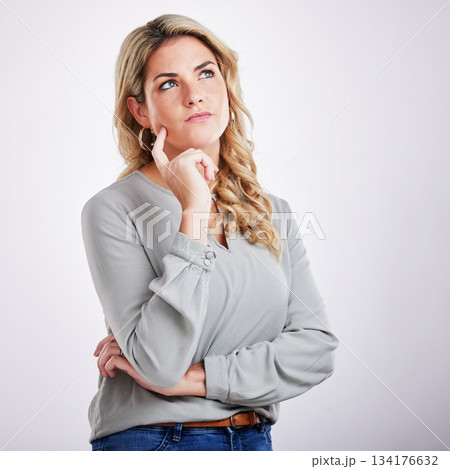 Thinking, mind and problem solving with a woman on a gray background in studio for contemplation. Idea, choice and decision making with an attractive young female contemplating in thoughtful wonder 134176632