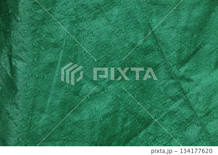 Green waterproof fabric texture covered in rain droplets background Green waterproof fabric texture covered in rain droplets background 134177620