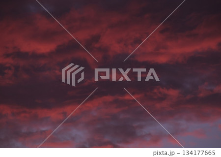 Fiery red storm clouds moving across dark sky background Fiery red storm clouds moving across dark sky background 134177665