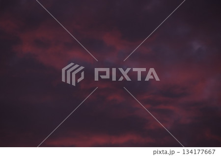 Dramatic dark purple and red clouds at deep sunset sky. Dramatic dark purple and red clouds at deep sunset sky. 134177667