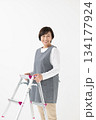 脚立を持つエプロン姿の女性 134177924