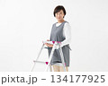 脚立を持つエプロン姿の女性 134177925