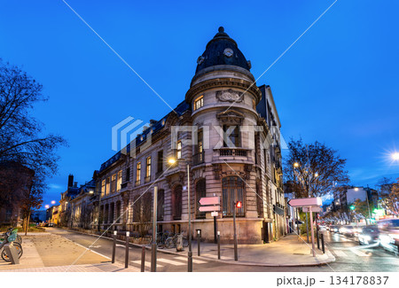 Historic administrative building stands on a street corner in Saint-Ouen-sur-Seine near Paris, France. Eclectic architecture features a stone facade and slate dome with "St Ouen" inscription 134178837