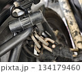 Close-up of a motorcycle security chain and lock attached to the frame. Shows details of metal links, padlock, and protective sleeve, ideal for illustrating security, protection, and anti-theft 134179460