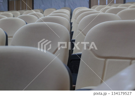 Close-up shot of multiple empty rows of beige auditorium seats for conference 134179527
