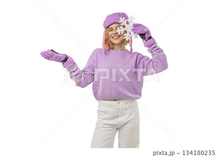 Girl in winter gear holding a snowflake, isolated, PNG 134180235