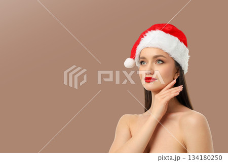 Woman in a red Santa hat with a neutral backdrop Woman in a red Santa hat with a neutral backdrop 134180250