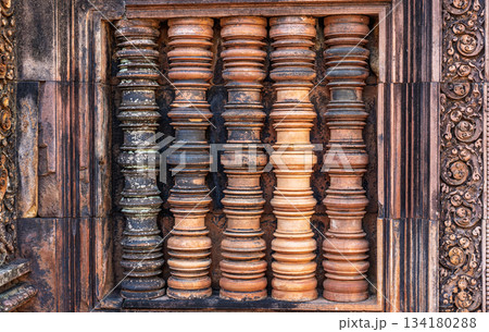 Ancient stone balusters window pillars detailed carving pink sandstone Khmer architecture temple history archaeology decoration geometric shape vertical row travel Ancient stone balusters window pillars detailed carving pink sandstone Khmer architecture temple history archaeology decoration geometric shape vertical row travel 134180288
