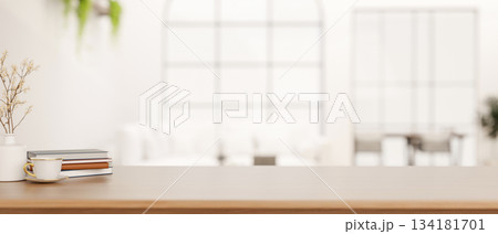 A cup of coffee and books aside flower vase on wooden counter table in bright living room or library A cup of coffee and books aside flower vase on wooden counter table in bright living room or library 134181701