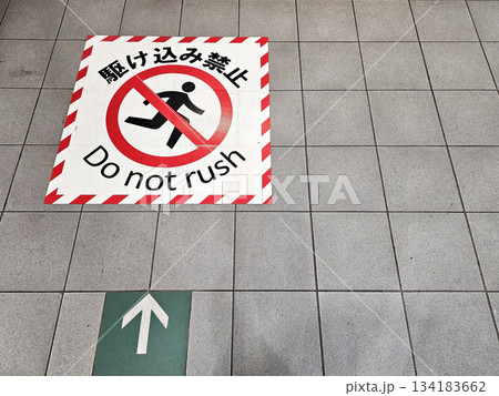 Do Not Rush Sign on Tiled Floor with Japanese Translation Rushing prohibited. 134183662