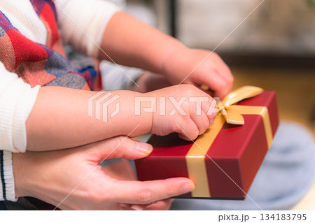 子供がプレゼントを開ける瞬間の手元の写真 ギフト ボックス 開封 シーン 134183795