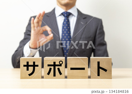 「サポート」と書かれたブロックとOKポーズをするビジネスマン 134184816