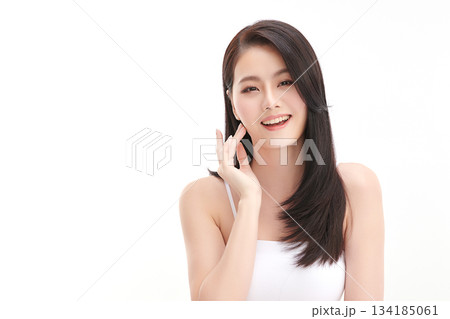 A beautiful young Asian woman with clean, fresh skin against a white background. Skincare, facial treatment, cosmetology, beauty, and spa. An elegant portrait of an Asian woman. 134185061