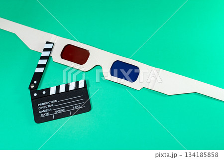A composition featuring a clapperboard with 3D glasses, all set on a vivid green background, highlighting cinema. 134185858