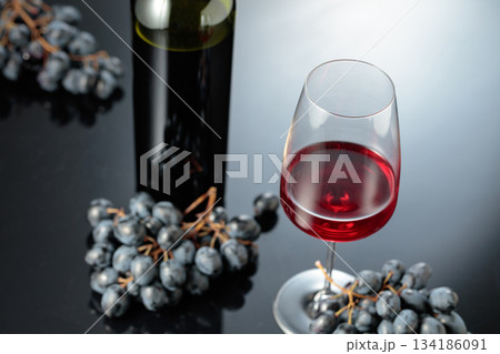 Red wine and juicy blue grapes. 134186091