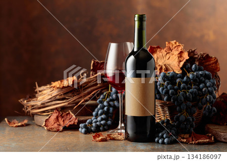 Red wine with blue grapes on a brown background. 134186097