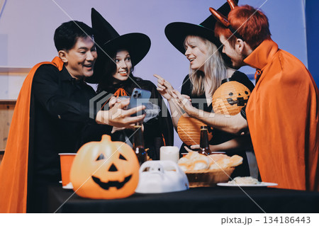 Friends enjoying a Halloween party at a bar making a toast 134186443