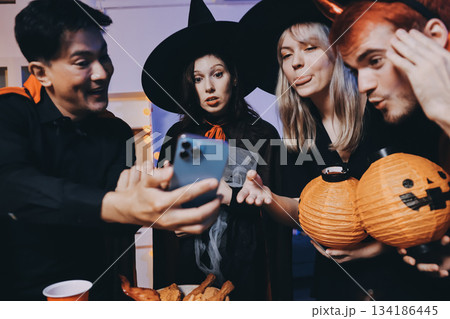Friends enjoying a Halloween party at a bar making a toast 134186445