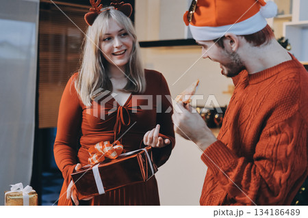 Festive Office Christmas Party with Delicious Food. A beautifully decorated office space with Christmas trees and festive lights, set up for a holiday party. 134186489