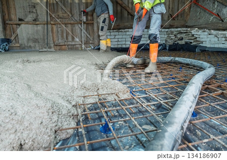 Pouring Concrete Slab with Reinforcement Construction Workers on Building Site Pouring Concrete Slab with Reinforcement Construction Workers on Building Site 134186907