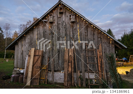 Rustic Wooden Barn with Birdhouses and Ladders in the Countryside at Twilight 134186961