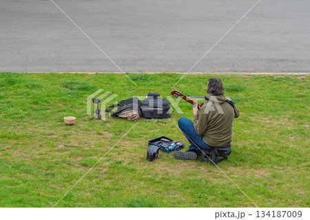 Guitarist Performing Outdoors A Musician s Creative Expression in a Public Park Setting Guitarist Performing Outdoors A Musician s Creative Expression in a Public Park Setting 134187009