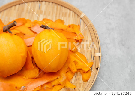 干し柿用に皮をむいた渋柿と、剝いた後の皮 134187249