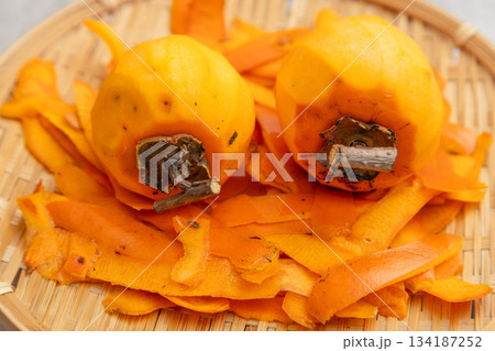 干し柿用に皮をむいた渋柿と、剝いた後の皮 134187252