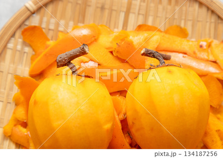 干し柿用に皮をむいた渋柿と、剝いた後の皮 干し柿用に皮をむいた渋柿と、剝いた後の皮 134187256