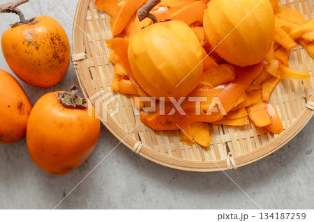 干し柿用に皮をむいた渋柿と、剝いた後の皮とむく前の柿 干し柿用に皮をむいた渋柿と、剝いた後の皮とむく前の柿 134187259