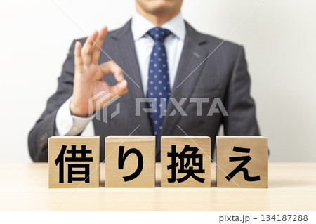 「借り換え」と書かれたブロックとOKポーズをするビジネスマン 「借り換え」と書かれたブロックとOKポーズをするビジネスマン 134187288