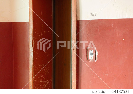 The inside of an old house where the paint is peeling off the walls. The door frame appears damaged, highlighting the neglect of the space. The setting reflects deterioration over time The inside of an old house where the paint is peeling off the walls. The door frame appears damaged, highlighting the neglect of the space. The setting reflects deterioration over time 134187581