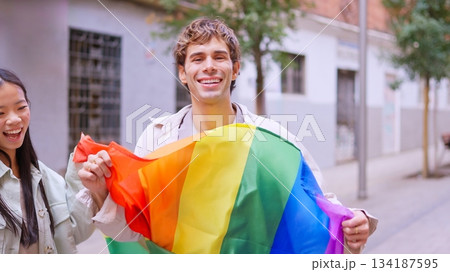 Happy young man holding rainbow flag for inclusion 134187595