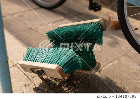 Shoe shine buckets are placed near an apartment building, providing a service for residents and passersby. Bicycles are parked close, suggesting a busy area for foot and bike traffic 134187598