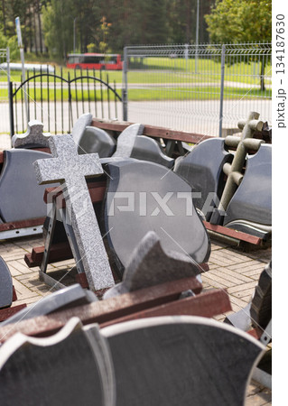 A variety of tombstones are displayed in an outdoor area, showcasing different shapes and sizes. The scene promotes grave markers available for purchase to honor loved ones A variety of tombstones are displayed in an outdoor area, showcasing different shapes and sizes. The scene promotes grave markers available for purchase to honor loved ones 134187630