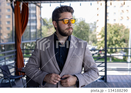 Confident businessman sitting in a modern cafe estaurant, portrait Confident businessman sitting in a modern cafe estaurant, portrait 134188290