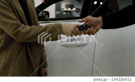 Close-up of a man's hands on the steering wheel, driving a new car 134188411