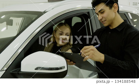 Happy woman sitting in new car and holding the key, smiling 134188548