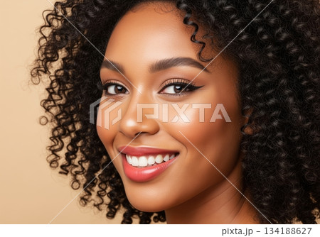 Beautiful young african woman with natural curly hair and radiant skin smiling brightly for a beauty campaign. 134188627