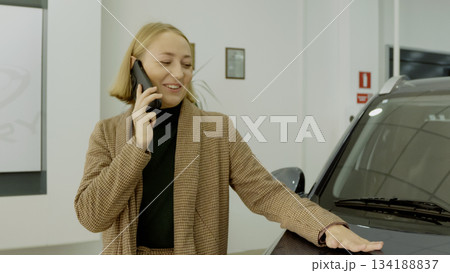 Happy woman getting out of car and smiling at camera 134188837
