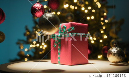 Red Christmas Gift Box Spins on a Turntable Against The Tree Red Christmas Gift Box Spins on a Turntable Against The Tree 134189138