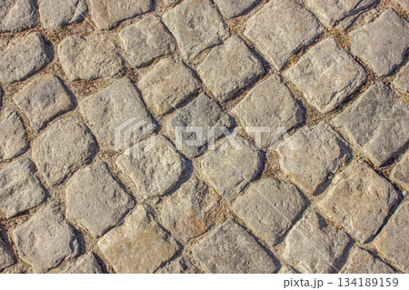 Cobblestone pavement background. Pavement road background. Bricks road. Brick surface background. Rough brick road Textured background. Sidewalk. Old cobblestone road. Cobblestone pavement background. Pavement road background. Bricks road. Brick surface background. Rough brick road Textured background. Sidewalk. Old cobblestone road. 134189159