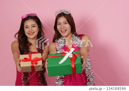 Party Fun. Friends posing with gifts and smiles at a vibrant celebration. Party Fun. Friends posing with gifts and smiles at a vibrant celebration. 134189599