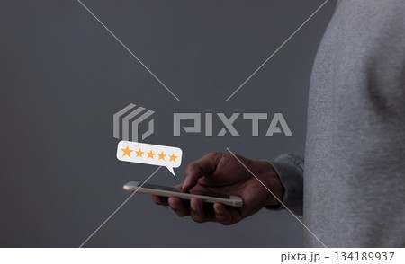 Review Customer, Young Man hand using smartphone mobile with five star to review and give 5 stars with very good results in service, Good review 5 star rating choice feedback 134189937