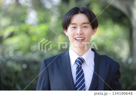 新緑背景で新卒の笑顔のビジネスマンカメラ目線 134190648