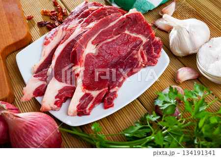Sliced raw veal steak with fresh parsley 134191341