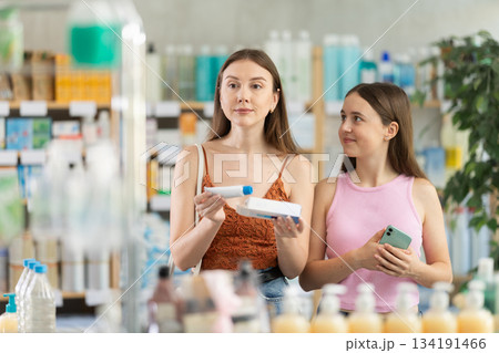 Woman with daughter choosing ointment in pharmacy Woman with daughter choosing ointment in pharmacy 134191466